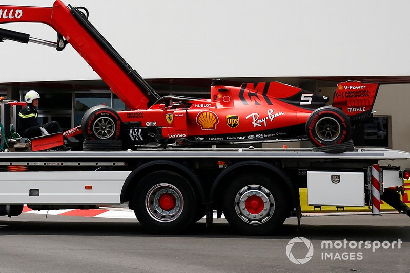 A truck returns the crashed Sebastian Vettel Ferrari SF90 back to the pit lane after FP3