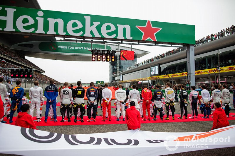 The drivers stand for the national anthem on the grid