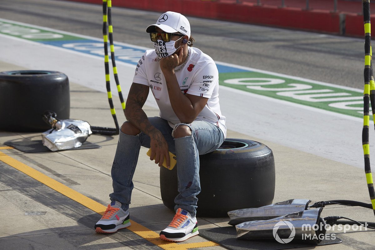 Lewis Hamilton, Mercedes-AMG F1, sits on a tyre in the pit lane