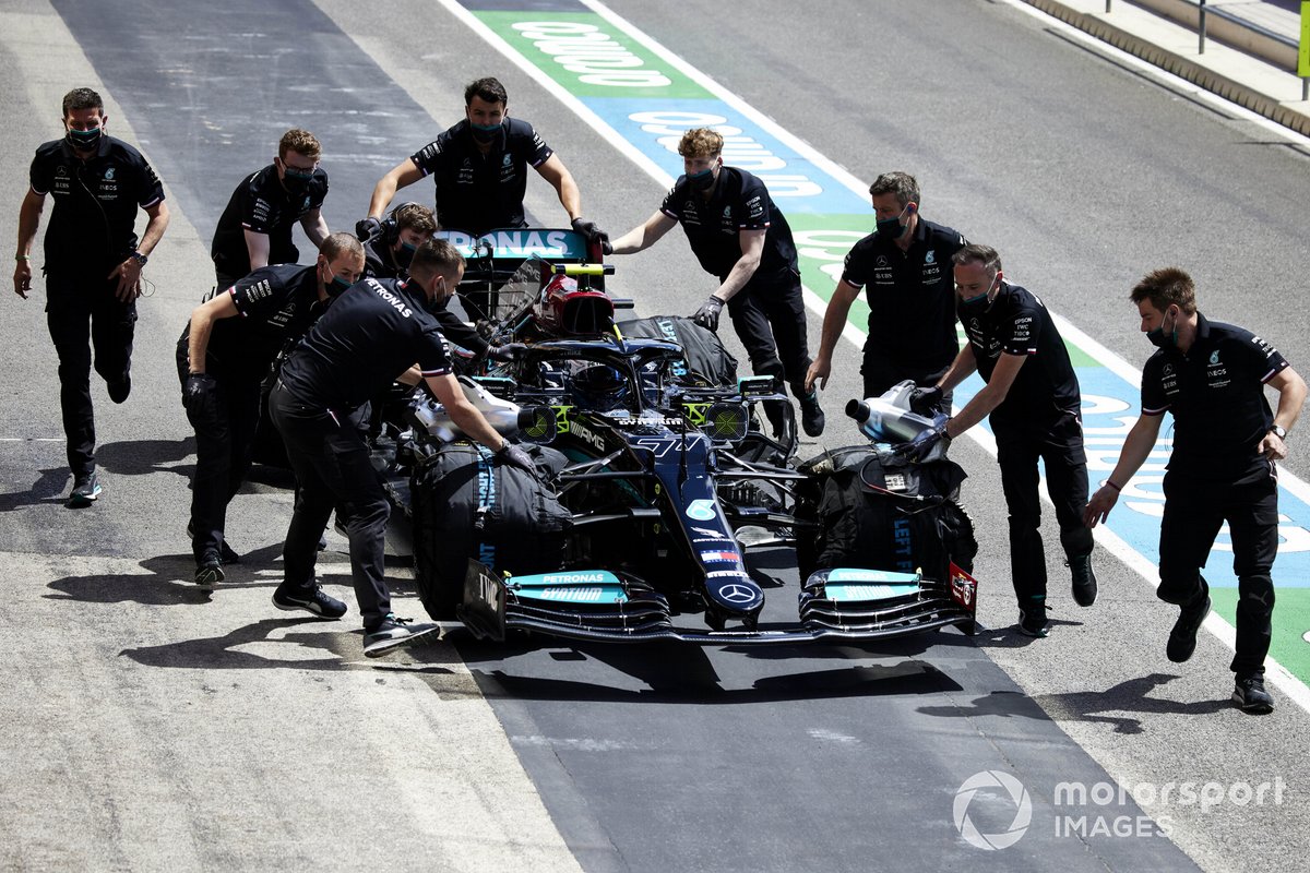 Mechanics move the car of Valtteri Bottas, Mercedes W12